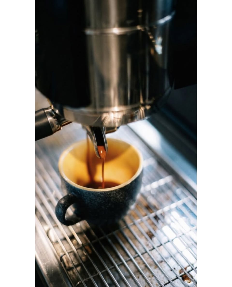 Espresso pulling into a speckled stoneware cup at Scara 0