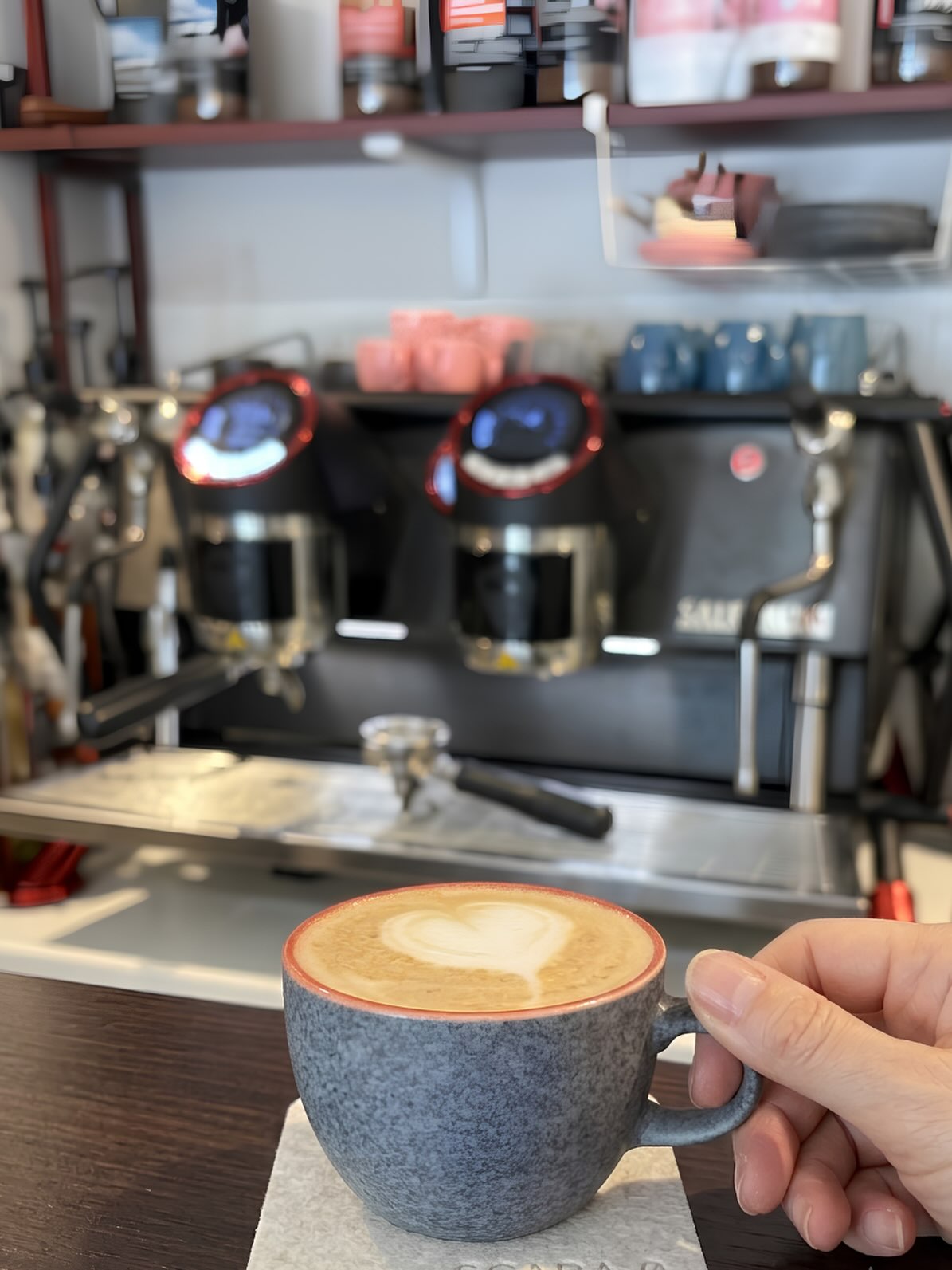 Latte art heart in a blue speckled cup at the Scara 0 machine
